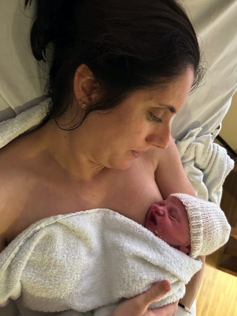 Leona holding her new baby, a VBAC success story