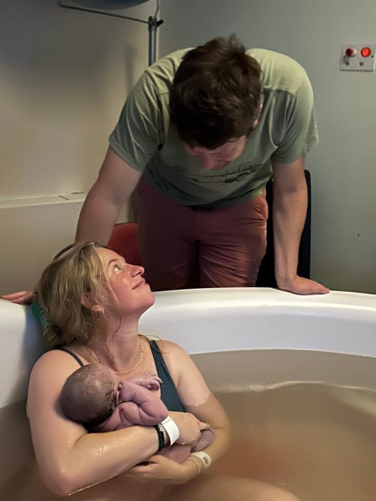 Lottie, holding her brand newborn baby in the pool on the Spires Midwife Led Unit, Oxford